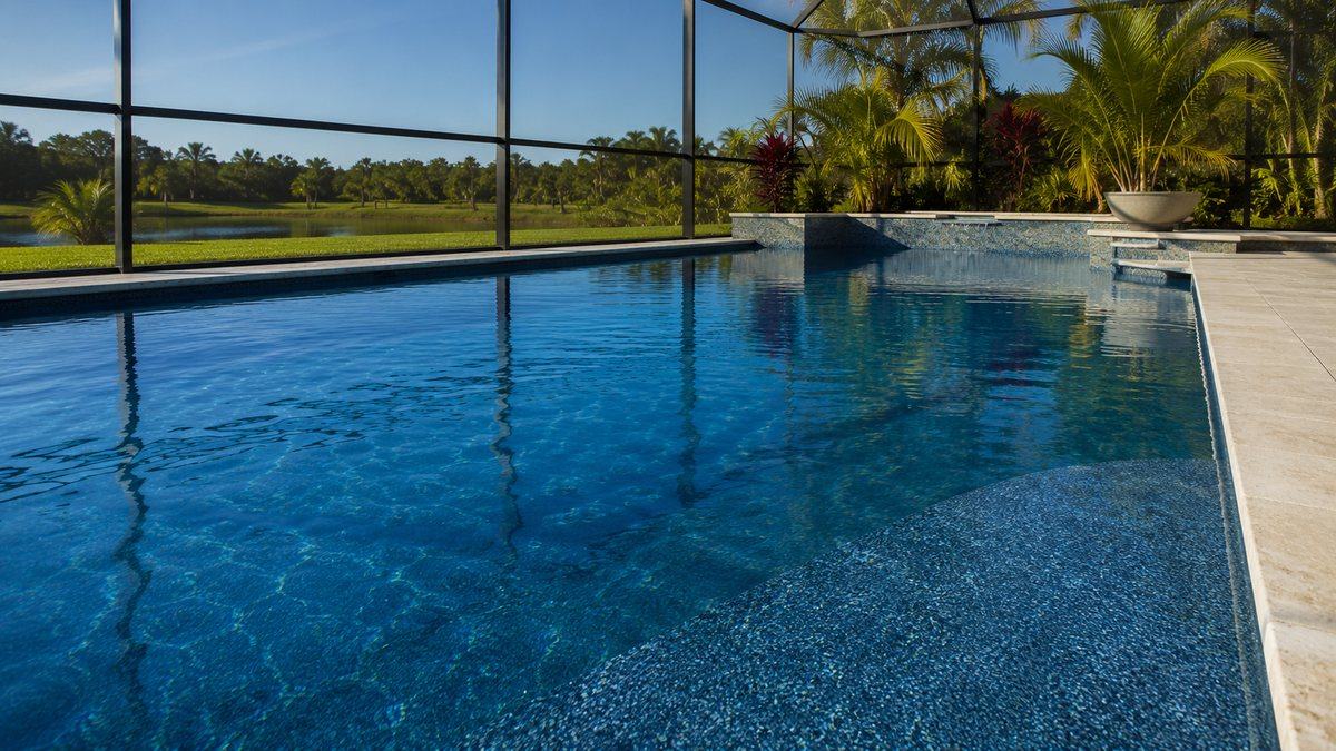 A residential pool with a rich blue quartz finish in a Cape Coral backyard